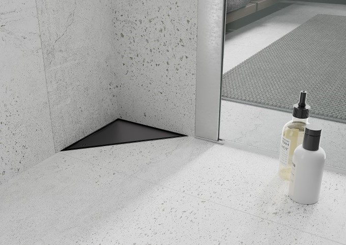 Black floor drain in a gray bathroom