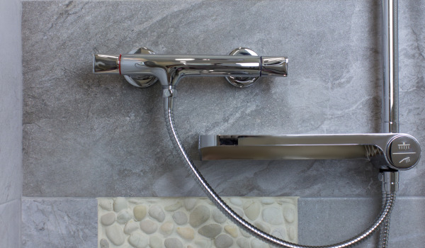 At what height should a wall-mounted bathtub faucet be installed?